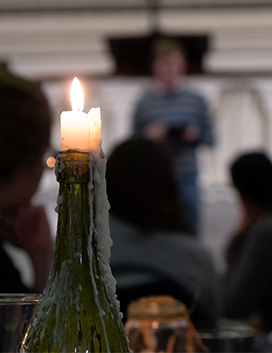 Candle in front of out of focus speaker at event
