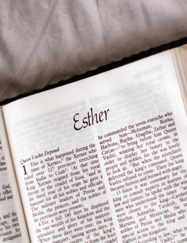 An open Bible with the word 'Esther' written on